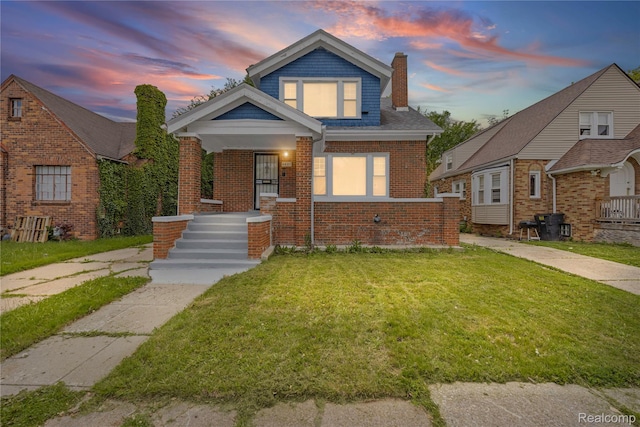 4627 Berkshire St, Detroit, MI 48224 - view of front of home featuring a chimney, a yard, brick siding, and a porch