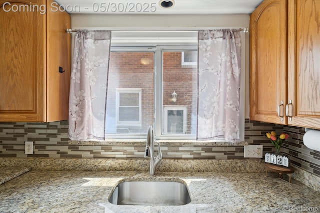 15645 Warwick Ave, Allen Park, MI 48101 - kitchen with a sink, decorative backsplash, light stone countertops, and brown cabinets
