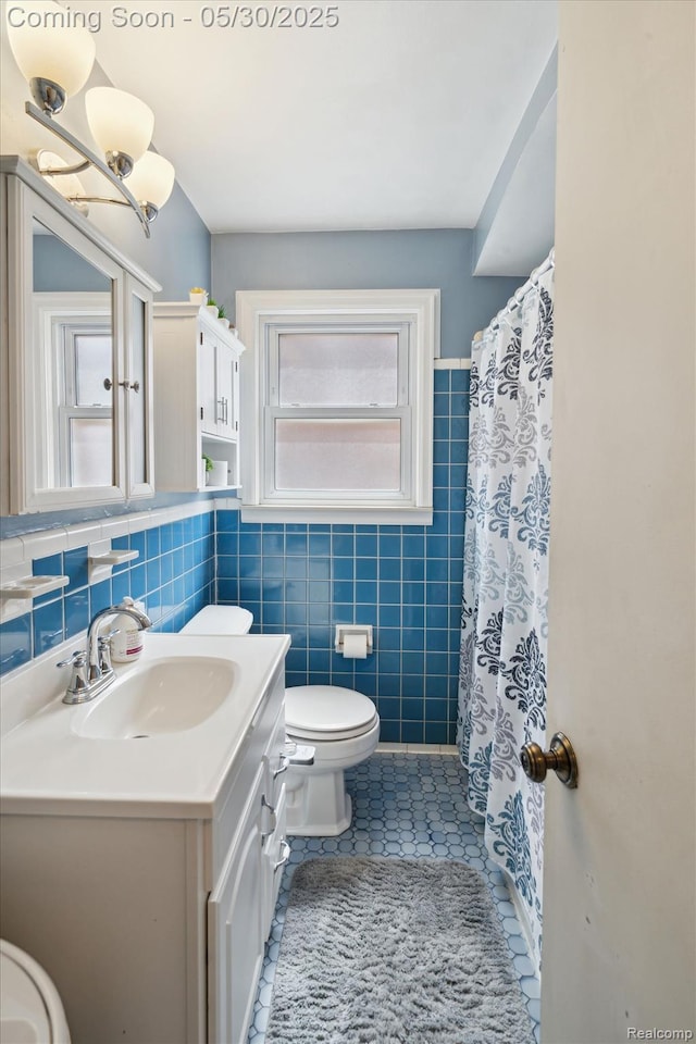 15645 Warwick Ave, Allen Park, MI 48101 - bathroom featuring tile walls, vanity, toilet, tile patterned flooring, and curtained shower