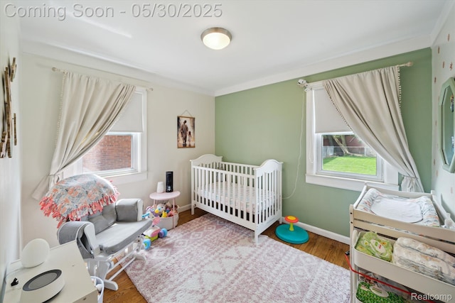 15645 Warwick Ave, Allen Park, MI 48101 - bedroom with wood finished floors, crown molding, baseboards, and a crib