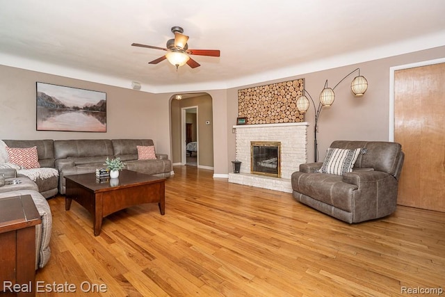 241 E Gunn Rd, Rochester, MI 48306 - living area featuring ceiling fan, light wood-type flooring, arched walkways, and a fireplace