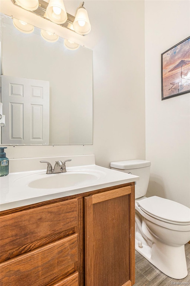 6140 Seymour Rd, Swartz Creek, MI 48473 - half bathroom with vanity, toilet, and wood finished floors
