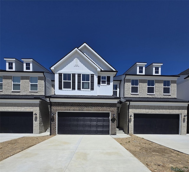 5555 E Spaniel Dr, Ann Arbor, MI 48108 - view of front facade featuring an attached garage, driveway, and stone siding