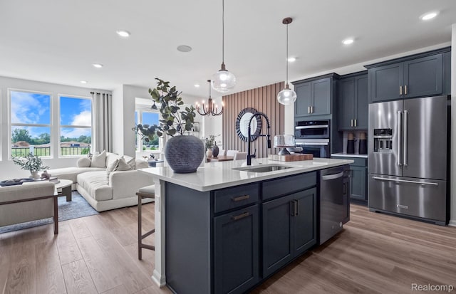 5555 E Spaniel Dr, Ann Arbor, MI 48108 - kitchen featuring stainless steel appliances, a sink, open floor plan, light countertops, and wood finished floors