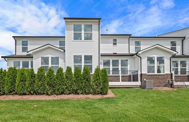 5555 E Spaniel Dr, Ann Arbor, MI 48108 - rear view of house featuring central air condition unit, a lawn, and brick siding