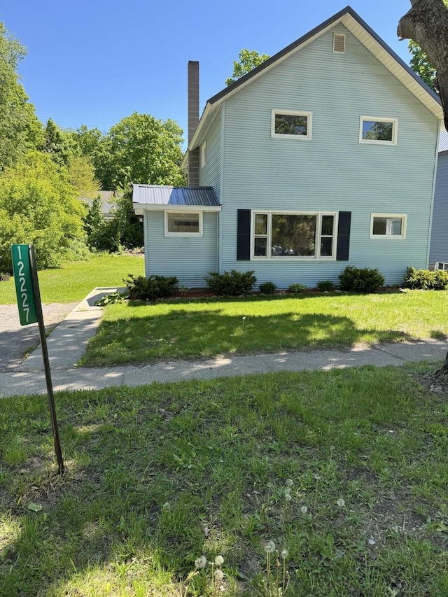 12227 Wise St, Bear Lake, MI 49614 - view of home's exterior with a chimney, a yard, and metal roof