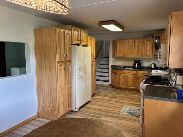 814 N Lakeview Ave, Sturgis, MI 49091 - kitchen with white appliances, light wood-type flooring, dark countertops, glass insert cabinets, and brown cabinets