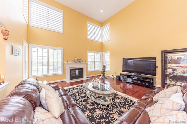 15390 Prestwick Cir, Northville, MI 48168 - living area with wood finished floors, a high ceiling, a fireplace with flush hearth, and baseboards