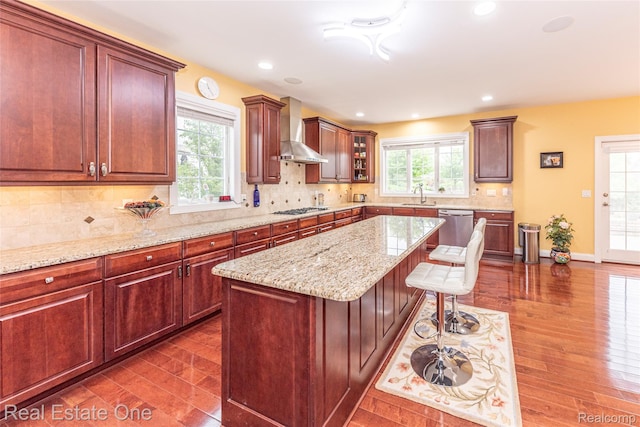 15390 Prestwick Cir, Northville, MI 48168 - kitchen featuring wall chimney range hood, a sink, gas cooktop, dark wood-type flooring, and recessed lighting