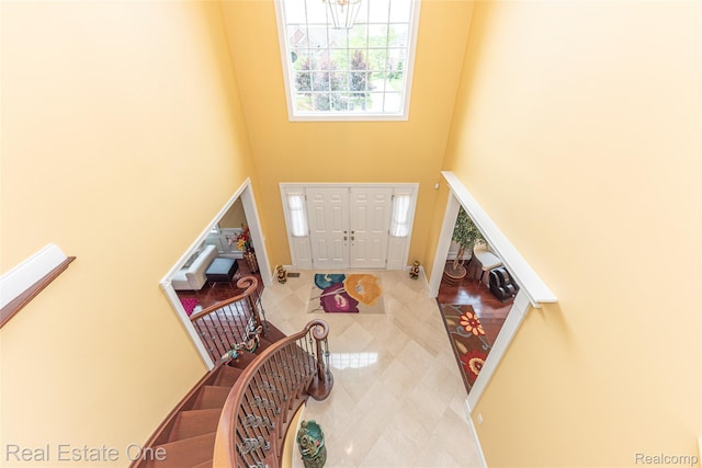 15390 Prestwick Cir, Northville, MI 48168 - foyer entrance featuring a towering ceiling, a chandelier, tile patterned floors, and baseboards