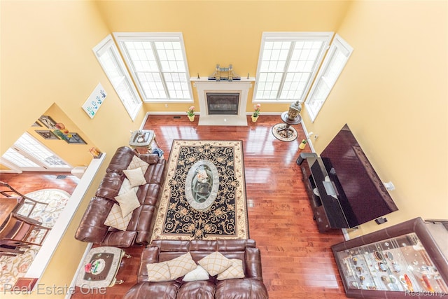 15390 Prestwick Cir, Northville, MI 48168 - living area with a high ceiling, wood finished floors, a fireplace with flush hearth, and baseboards