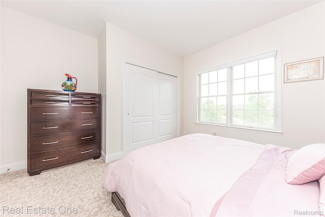 15390 Prestwick Cir, Northville, MI 48168 - bedroom with baseboards, light carpet, and a closet
