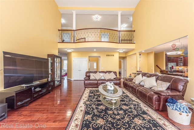 15390 Prestwick Cir, Northville, MI 48168 - living area featuring wood finished floors, ornate columns, and a towering ceiling