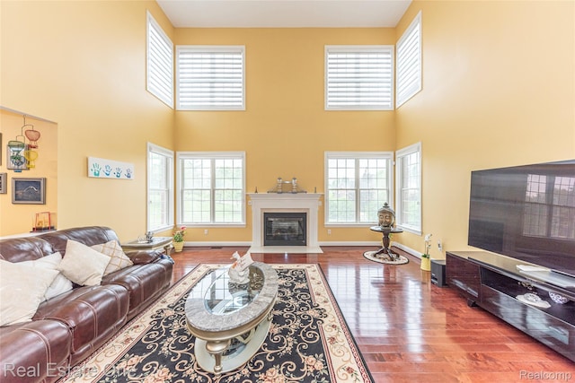 15390 Prestwick Cir, Northville, MI 48168 - living area featuring plenty of natural light, hardwood / wood-style flooring, a fireplace with flush hearth, and a towering ceiling