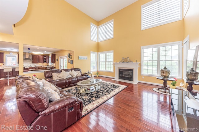 15390 Prestwick Cir, Northville, MI 48168 - living room with dark wood finished floors, plenty of natural light, a towering ceiling, and a fireplace with flush hearth