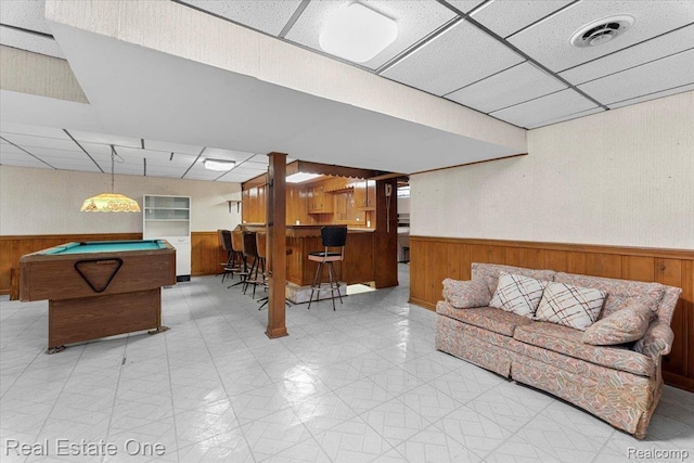 8424 Roosevelt St, Taylor, MI 48180 - living room featuring a paneled ceiling, wainscoting, bar, wood walls, and billiards