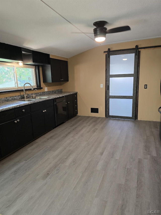 124 N Madison St, Adrian, MI 49221 - kitchen featuring dishwasher, dark cabinets, a barn door, light wood-style flooring, and ceiling fan