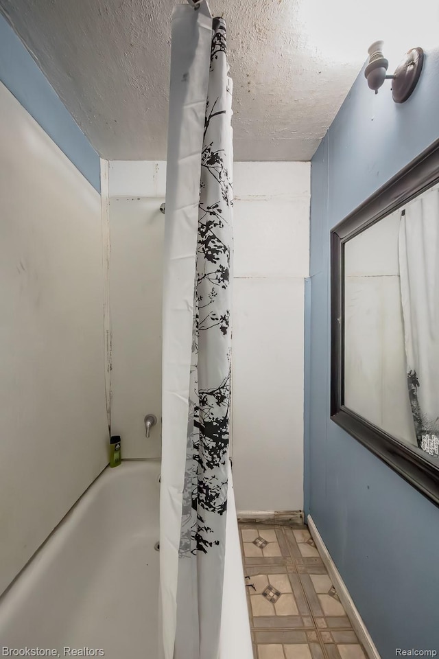 725 E Sherman St, Holly, MI 48442 - bathroom featuring a textured ceiling, tile patterned floors, and shower / bath combination with curtain