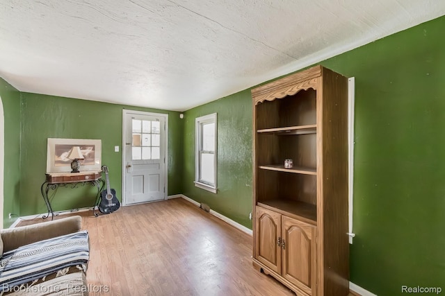 725 E Sherman St, Holly, MI 48442 - living room featuring light wood-type flooring, baseboards, and a textured ceiling