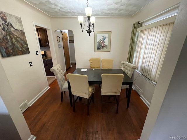 13960 Mettetal St, Detroit, MI 48227 - dining room with dark wood-style floors, arched walkways, a chandelier, and baseboards