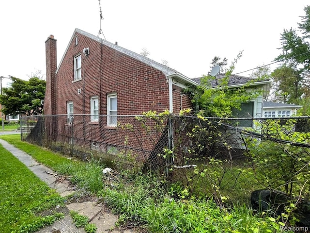 13960 Mettetal St, Detroit, MI 48227 - view of side of home featuring brick siding and a chimney