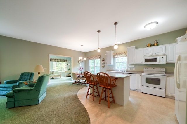 5610 Copper Sands Run, Fruitport, MI 49415 - kitchen with white appliances, white cabinetry, a breakfast bar area, pendant lighting, and a center island