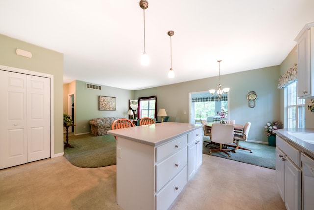 5610 Copper Sands Run, Fruitport, MI 49415 - kitchen featuring light countertops, a center island, light colored carpet, and decorative light fixtures