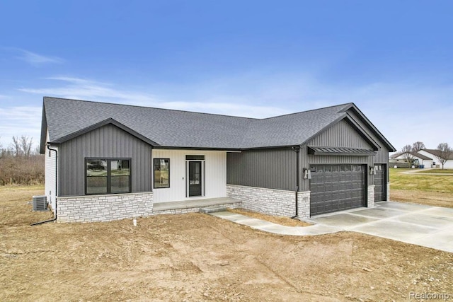 7195 Geraldine Cir, Swartz Creek, MI 48473 - modern farmhouse style home featuring roof with shingles, a garage, central AC unit, and stone siding
