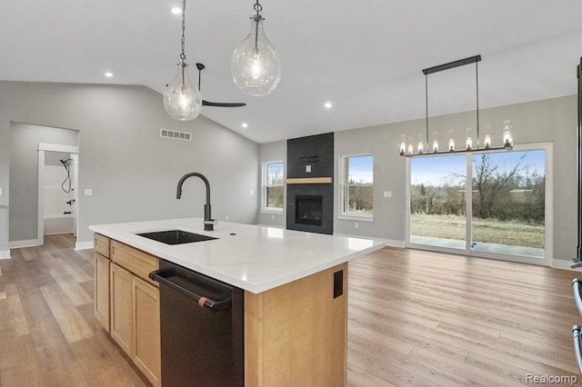7195 Geraldine Cir, Swartz Creek, MI 48473 - kitchen with dishwashing machine, a sink, open floor plan, light wood-style floors, and lofted ceiling