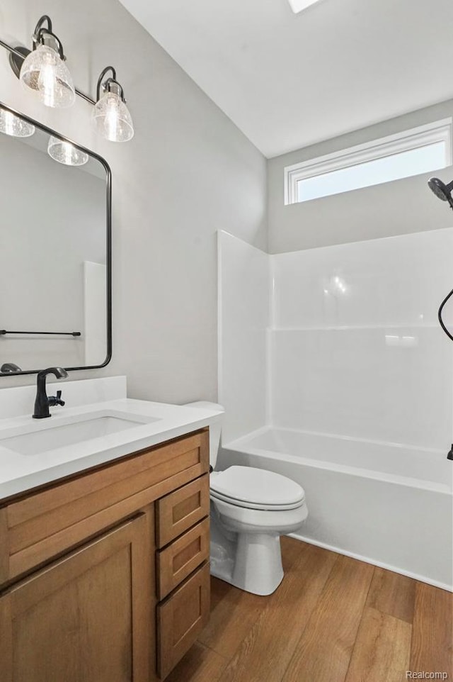 7195 Geraldine Cir, Swartz Creek, MI 48473 - full bath with wood finished floors, vanity, toilet, and shower / washtub combination