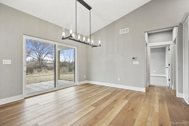 7195 Geraldine Cir, Swartz Creek, MI 48473 - unfurnished dining area with wood finished floors, baseboards, and a chandelier