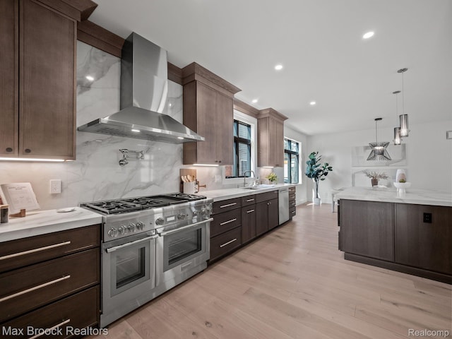 667 Oak Ave, Birmingham, MI 48009 - kitchen with stainless steel appliances, wall chimney range hood, a sink, backsplash, and dark brown cabinets