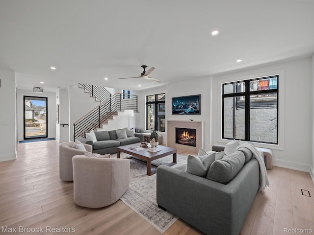 667 Oak Ave, Birmingham, MI 48009 - living room with stairs, healthy amount of natural light, light wood-type flooring, recessed lighting, and a warm lit fireplace