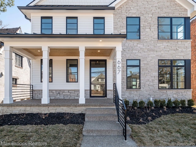 667 Oak Ave, Birmingham, MI 48009 - view of front of home with a standing seam roof, a porch, stone siding, and metal roof