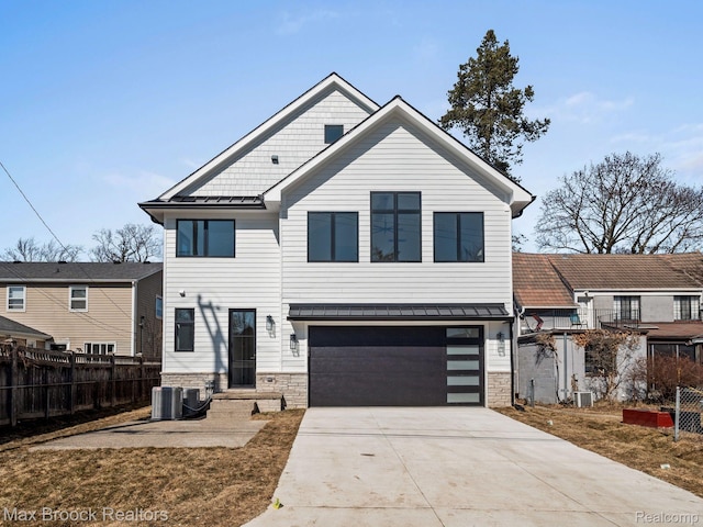667 Oak Ave, Birmingham, MI 48009 - view of front of home with stone siding, a standing seam roof, an attached garage, concrete driveway, and metal roof