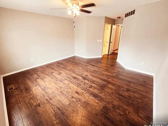 9418 Rayna Dr Unit 62, Davison, MI 48423 - unfurnished room featuring dark wood-style flooring, ceiling fan, and baseboards
