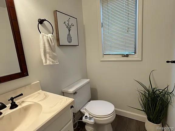 9418 Rayna Dr Unit 62, Davison, MI 48423 - bathroom featuring toilet, vanity, wood finished floors, and baseboards