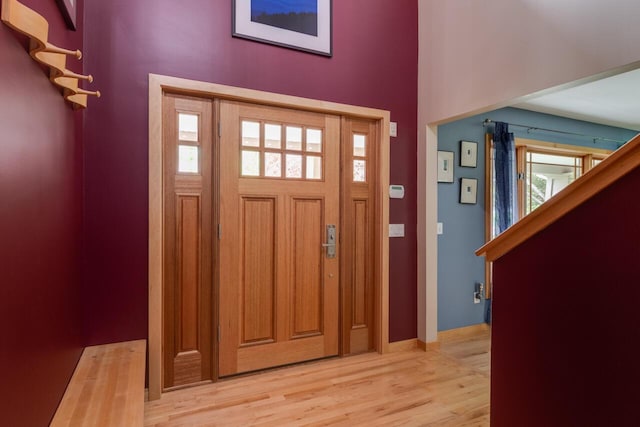 7346 Dunross Dr, Portage, MI 49024 - foyer entrance with light wood finished floors, a high ceiling, baseboards, and stairs