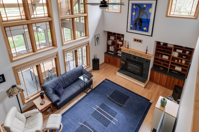 7346 Dunross Dr, Portage, MI 49024 - living room featuring a high ceiling, wood finished floors, ceiling fan, and a tile fireplace