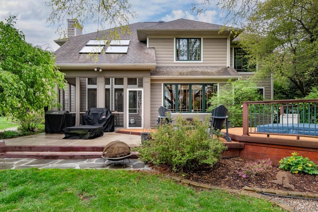 7346 Dunross Dr, Portage, MI 49024 - rear view of house with a fire pit, a wooden deck, roof with shingles, and a chimney
