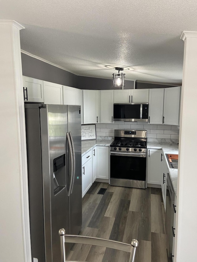 4050 Larkspur Ln, Muskegon, MI 49442 - kitchen with stainless steel appliances, a textured ceiling, decorative backsplash, white cabinets, and dark wood-type flooring