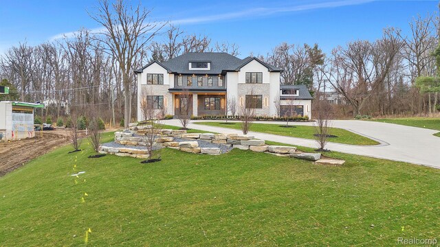 4627 Cimarron Dr, Bloomfield Hills, MI 48302 - view of front of house featuring a balcony, a front lawn, stone siding, and concrete driveway