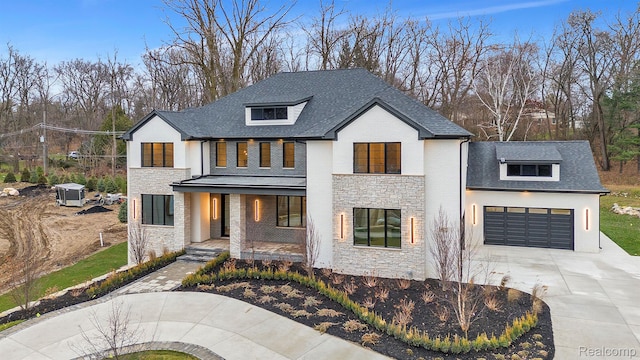 4627 Cimarron Dr, Bloomfield Hills, MI 48302 - view of front of home featuring stone siding, covered porch, concrete driveway, a garage, and roof with shingles