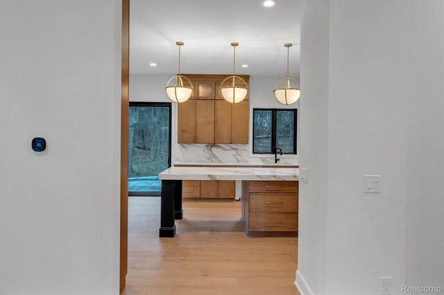 4627 Cimarron Dr, Bloomfield Hills, MI 48302 - kitchen featuring brown cabinetry, light wood-style floors, recessed lighting, tasteful backsplash, and plenty of natural light