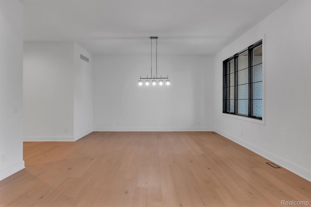 4627 Cimarron Dr, Bloomfield Hills, MI 48302 - unfurnished dining area with light wood-type flooring, a chandelier, and baseboards