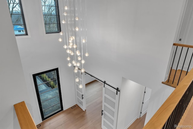 4627 Cimarron Dr, Bloomfield Hills, MI 48302 - stairs featuring a barn door, a high ceiling, wood finished floors, and plenty of natural light