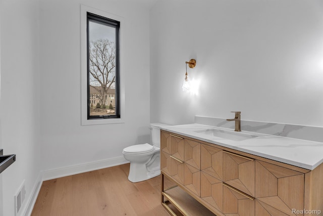 4627 Cimarron Dr, Bloomfield Hills, MI 48302 - half bath with toilet, vanity, wood finished floors, and baseboards