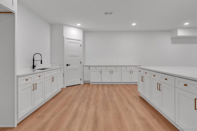 4627 Cimarron Dr, Bloomfield Hills, MI 48302 - kitchen featuring a sink, white cabinetry, light wood-style floors, recessed lighting, and light countertops