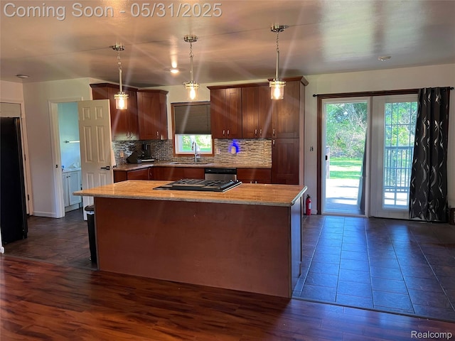 1150 E Hill Rd, Grand Blanc, MI 48439 - kitchen with a center island, decorative backsplash, dishwasher, freestanding refrigerator, and gas cooktop