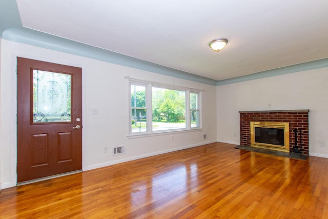 4225 Central Blvd, Ann Arbor, MI 48108 - unfurnished living room featuring light wood-style floors, baseboards, and a brick fireplace